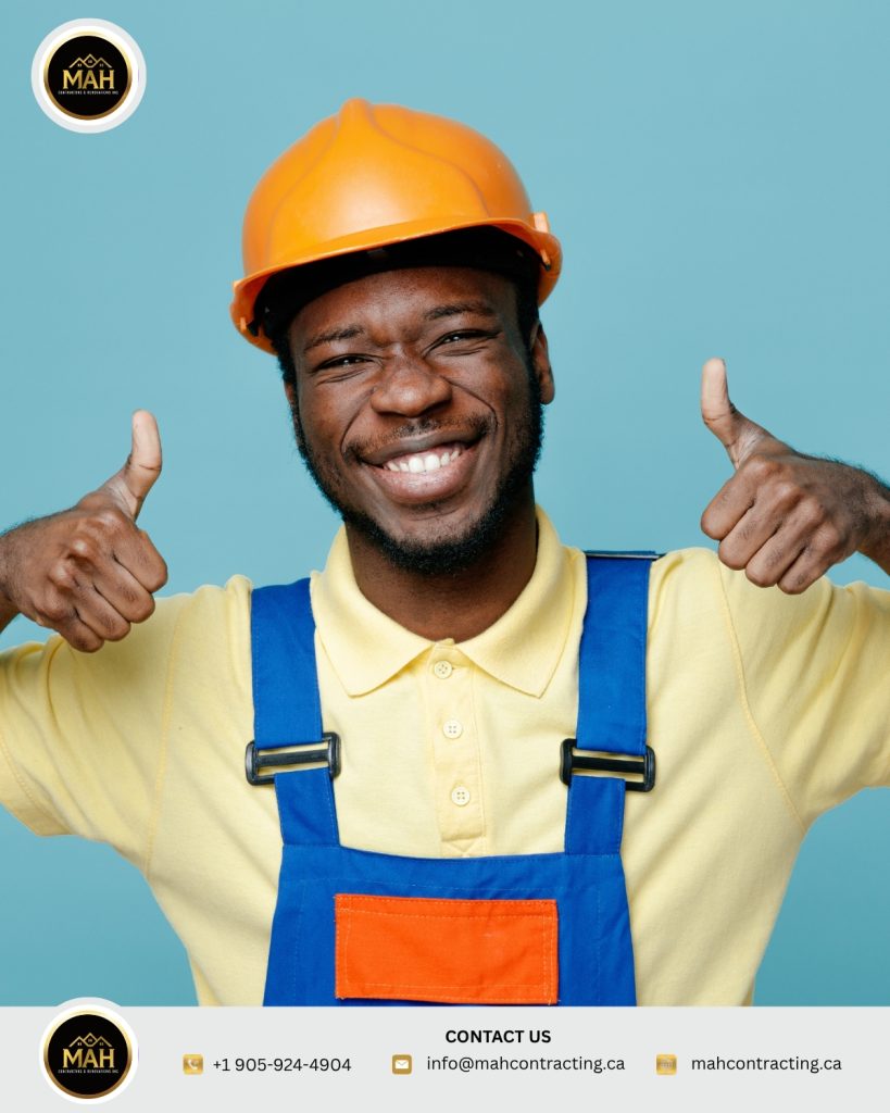 Smiling contractor in a hard hat giving two thumbs up